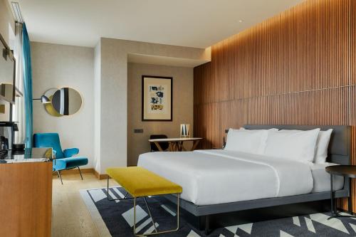 a bedroom with a large white bed and a desk at Le Meridien Batumi in Batumi