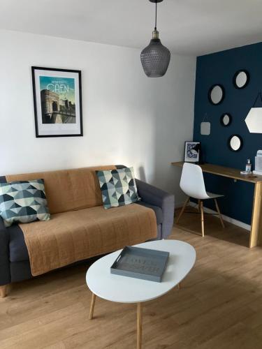 a living room with a couch and a table at CAEN : appartement Cosy hyper centre historique in Caen