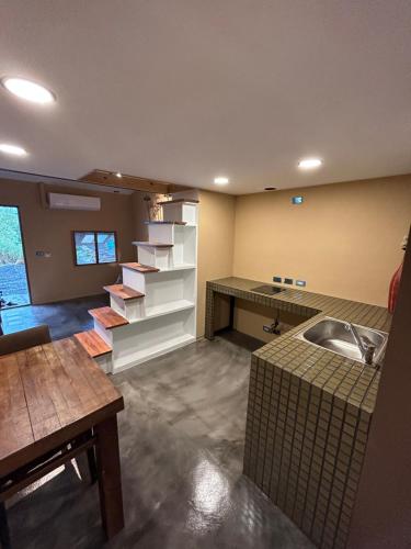 a kitchen with a sink and a shelf with books at 池上包棟民宿-莊稼熟了三館 in Chishang