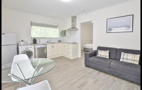 a living room with a couch and a glass table at Mildura Holiday Villas in Mildura