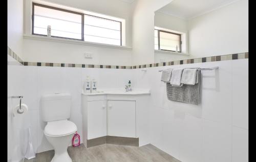 a white bathroom with a toilet and a sink at Mildura Holiday Villas in Mildura