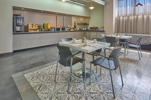 メキシコシティにあるCity Express Plus by Marriott Ciudad de México Patio Universidadのテーブルと椅子が2脚あるレストラン