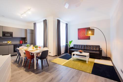 een woonkamer met een tafel en een bank bij LAIMA RENDEZVOUS APARTMENTS in Rīga