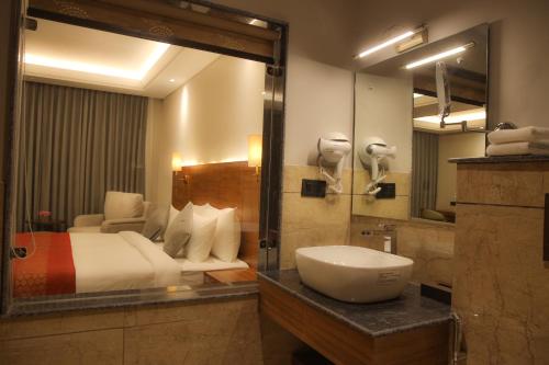 a bathroom with a bed and a sink and a mirror at Casa Galwan in Leh