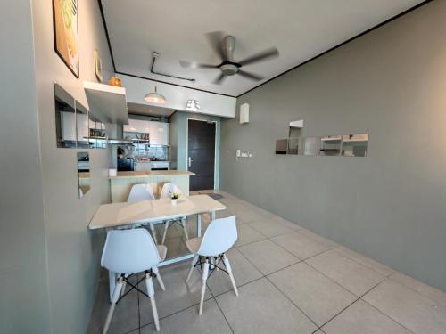 a dining room with a table and white chairs at Modern Comfy Suite Room-9Pax in Perai