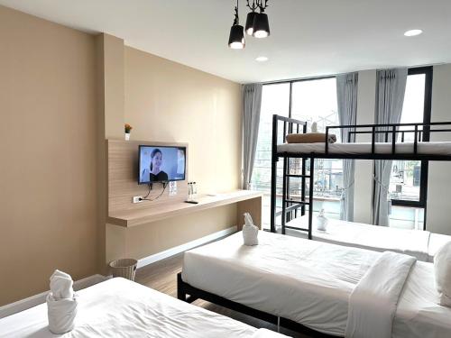 a bedroom with two bunk beds and a tv at บันดารี่ ริชชี่ (Bhundaree Richy) in Hat Yai