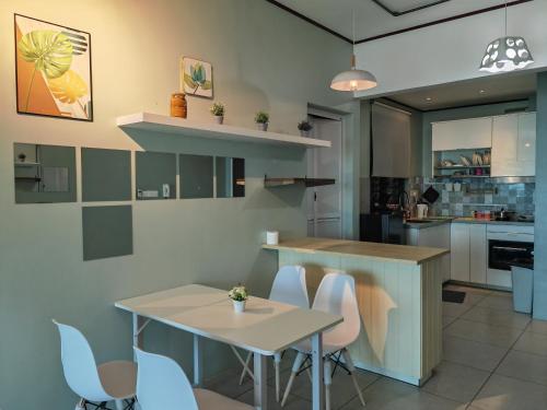 a kitchen with a table and chairs and a counter at Modern Comfy Suite Room-9Pax in Perai