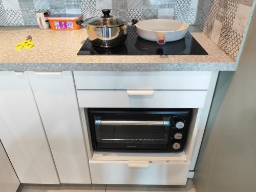 a microwave oven in a kitchen with a counter at Modern Comfy Suite Room-9Pax in Perai