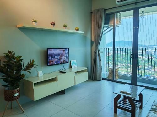 - un salon avec une télévision et une grande fenêtre dans l'établissement Modern Comfy Suite Room-9Pax, à Perai