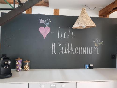 a chalkboard wall with a helloulum sign on a kitchen counter at Historisch grosszügiges Haus in Glarus