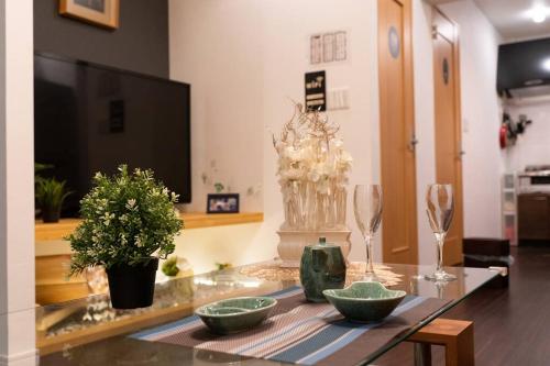 a living room with a glass table with bowls and wine glasses at 锦·【金太閣】名古屋駅徒歩700m超大空间まるまる貸切 in Nagoya