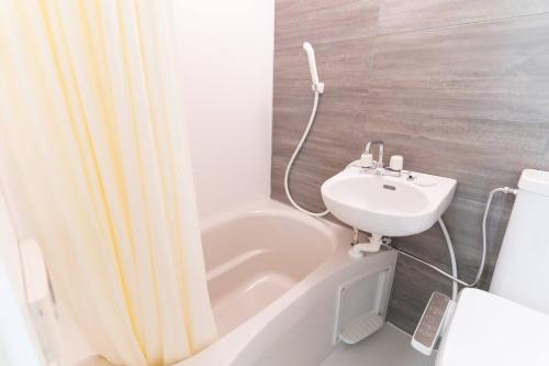a bathroom with a sink and a tub and a toilet at 锦·【金太閣】名古屋駅徒歩700m超大空间まるまる貸切 in Nagoya