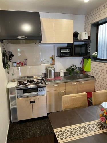 a small kitchen with a stove and a table at 锦·【金太閣】名古屋駅徒歩700m超大空间まるまる貸切 in Nagoya