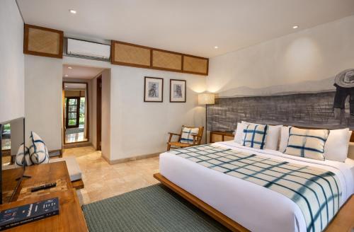 a bedroom with a large bed and a desk at Dinara Ubud in Ubud