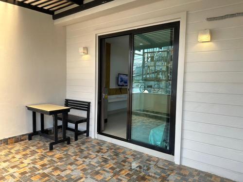 a glass door with a table and a chair on a house at บันดารี่ ริชชี่ (Bhundaree Richy) in Hat Yai
