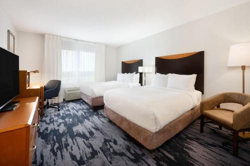 a hotel room with two beds and a television at Fairfield Inn & Suites Fort Pierce / Port St Lucie in Fort Pierce