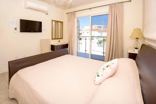 una camera da letto con un letto e una grande finestra di Villa Athena a Protaras