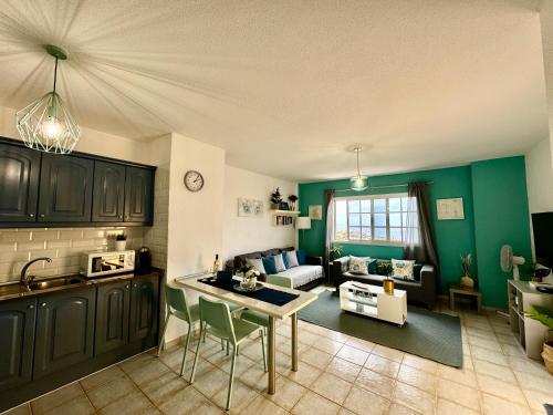 cocina y sala de estar con paredes verdes en Sunset View Balcon del Atlantico fase IV in Torviscas en Adeje