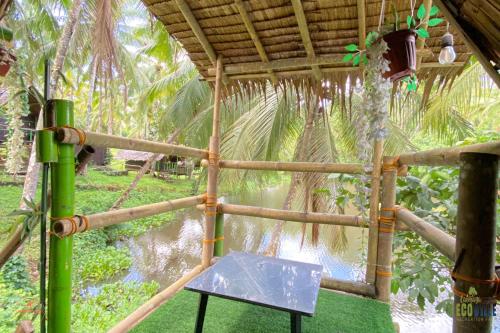 a bamboo structure with a table in front of a body of water at Caliraya Ecoville Recreation and Farm Resort in Cavinti