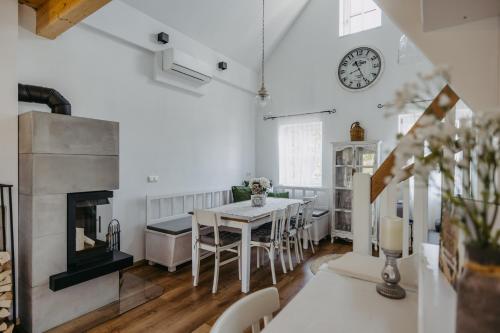 a dining room with a table and a clock on the wall at Kellerstöckl Das Csaterberg in Csatherberg