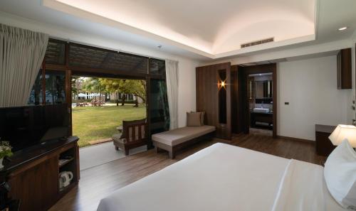 a bedroom with a bed and a television and a couch at Celes Samui in Bophut