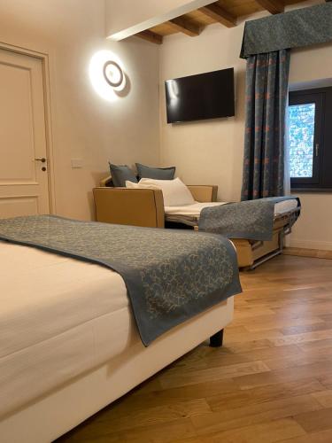 a hotel room with two beds and a tv at Cà Uberti Palace Hotel, MantegnaHotels in Mantova