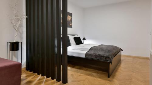 a bedroom with a bed with a black curtain at La Vie - Deluxe Studio Apartment in Zagreb