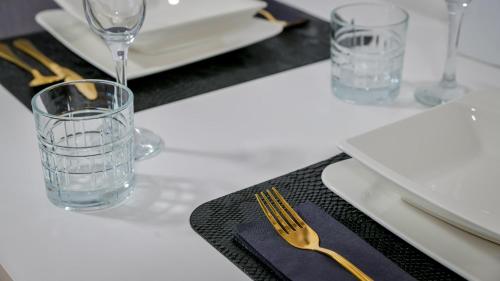 a table with a fork and a glass on a table at La Vie - Deluxe Studio Apartment in Zagreb