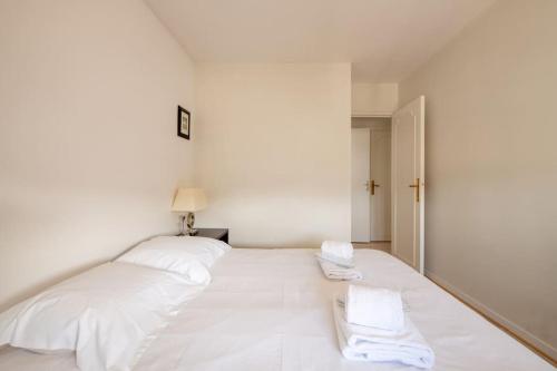 un letto bianco con due cuscini bianchi di Bellevue - Superbe appartement avec vue, à pont de Sèvre a Boulogne-Billancourt