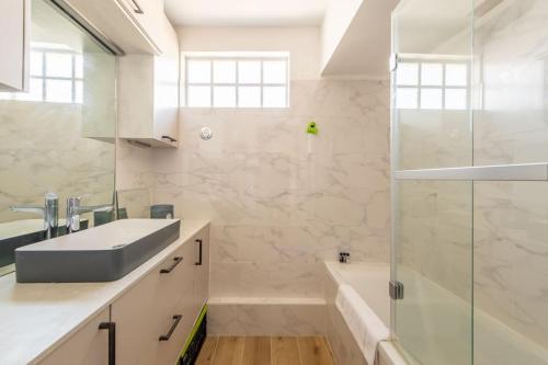 ein Bad mit einem Waschbecken und einer Dusche in der Unterkunft Bellevue - Superbe appartement avec vue, à pont de Sèvre in Boulogne-Billancourt