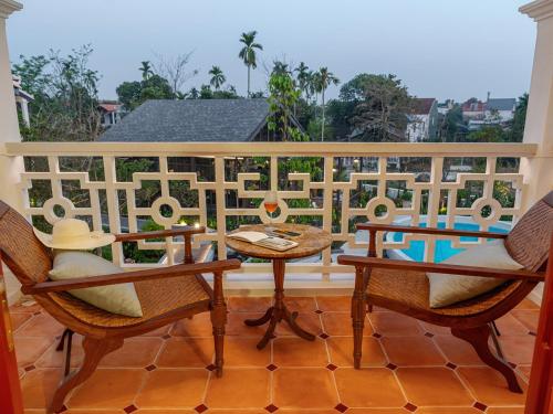a balcony with two chairs and a table on a balcony at Ancient Huế Garden Houses in Hue
