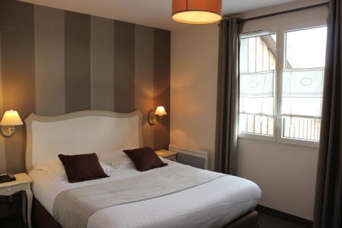 a bedroom with a large bed and a window at Clos De La Vaupalière - Rouen in La Vaupalière