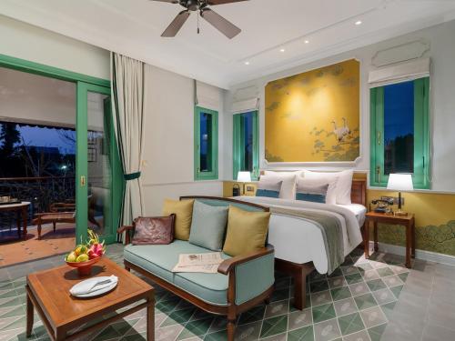 a hotel room with a bed and a couch at Ancient Huế Garden Houses in Hue