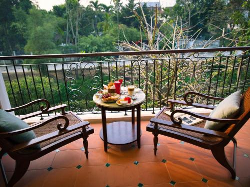 a balcony with a table with a plate of food on it at Ancient Huế Garden Houses in Hue