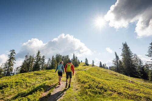 two people walking down a hill on a trail at Landhaus Riepler in Wagrain