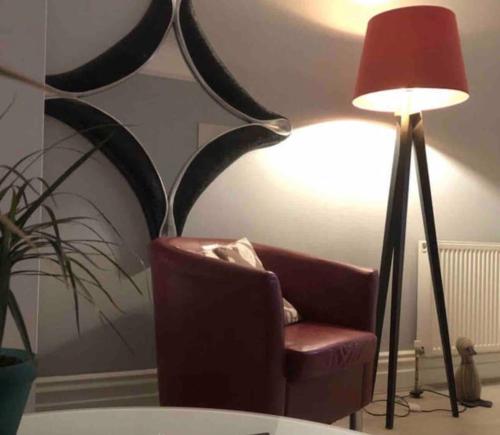 uma sala de estar com uma cadeira vermelha e um candeeiro em Bournemouth. Private Self Contained space. em Bournemouth