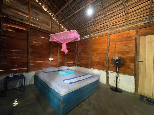 ein Zimmer mit einem Bett mit einem rosa Regenschirm darauf in der Unterkunft araliya villa in Kalpitiya