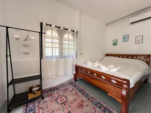 1 dormitorio con cama y ventana en Cozy house in Chaloklum, en Mae Haad