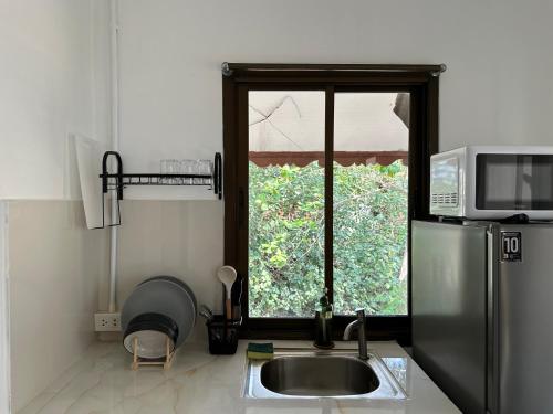 cocina con fregadero y ventana en Cozy house in Chaloklum, en Mae Haad