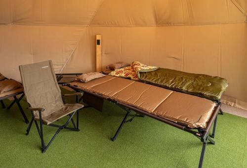 a room with a bed and a chair in it at KURA Nagomi Hida Takayama - Camp - Vacation STAY 62749v in Takayama