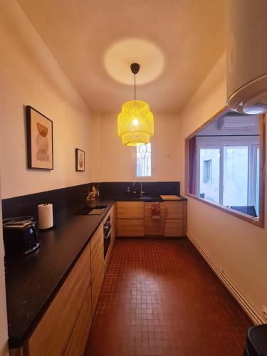 a kitchen with a black counter top and a window at Appartement intra muros avec cour privée in Avignon