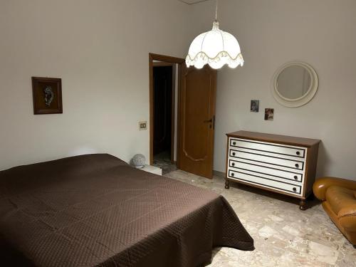 ポルト・サン・ジョルジョにあるAppartamento Sul Mareのベッドルーム1室(ベッド1台、ドレッサー、シャンデリア付)