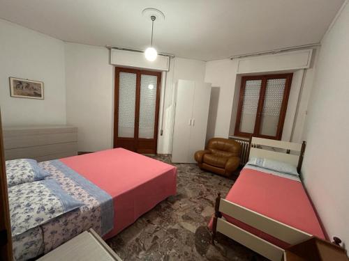een slaapkamer met 2 bedden en een stoel bij Appartamento Sul Mare in Porto San Giorgio