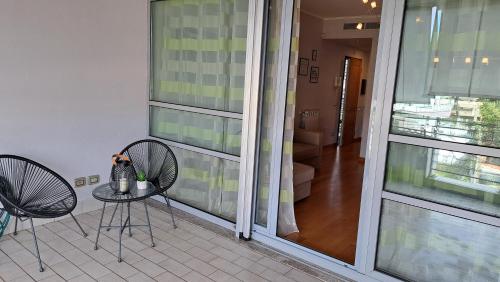 een balkon met 2 stoelen en een tafel met uitzicht op een gang bij Appartamento Le Vele in Fiumicino