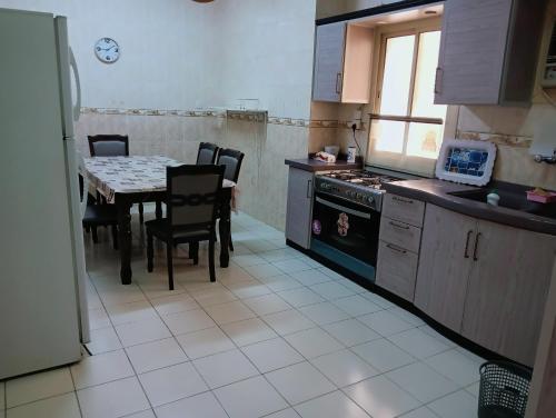 een keuken met een tafel en een fornuis en een tafel en stoelen bij Soma Apt in Al Madinah