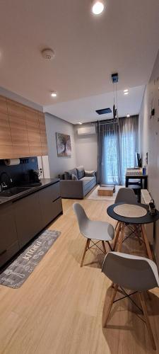 a living room with a table and chairs and a kitchen at Lago Suite in Kastoria