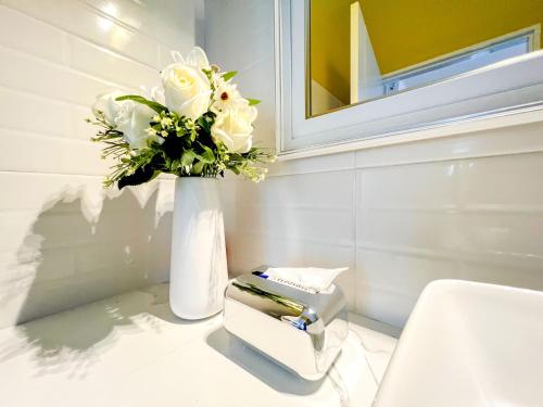 een badkamer met een vaas met bloemen en een tissues bij One Villa Samaesarn in Ban Samae San