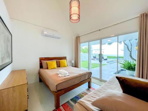 a bedroom with a bed and a large window at One Villa Samaesarn in Ban Samae San