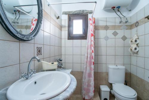 a bathroom with a sink and a toilet and a mirror at Savvas's Traditional House Paros in Episkopianá