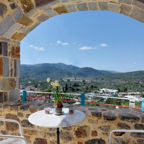a table with a vase of flowers on a balcony at Roza Stone Studio & Suite in Goníai